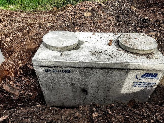 Concrete septic tank set in an excavation